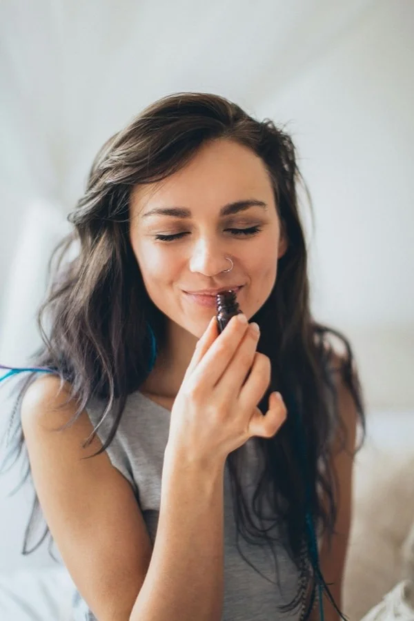Mujer percibiendo el aroma de un producto cosmético
