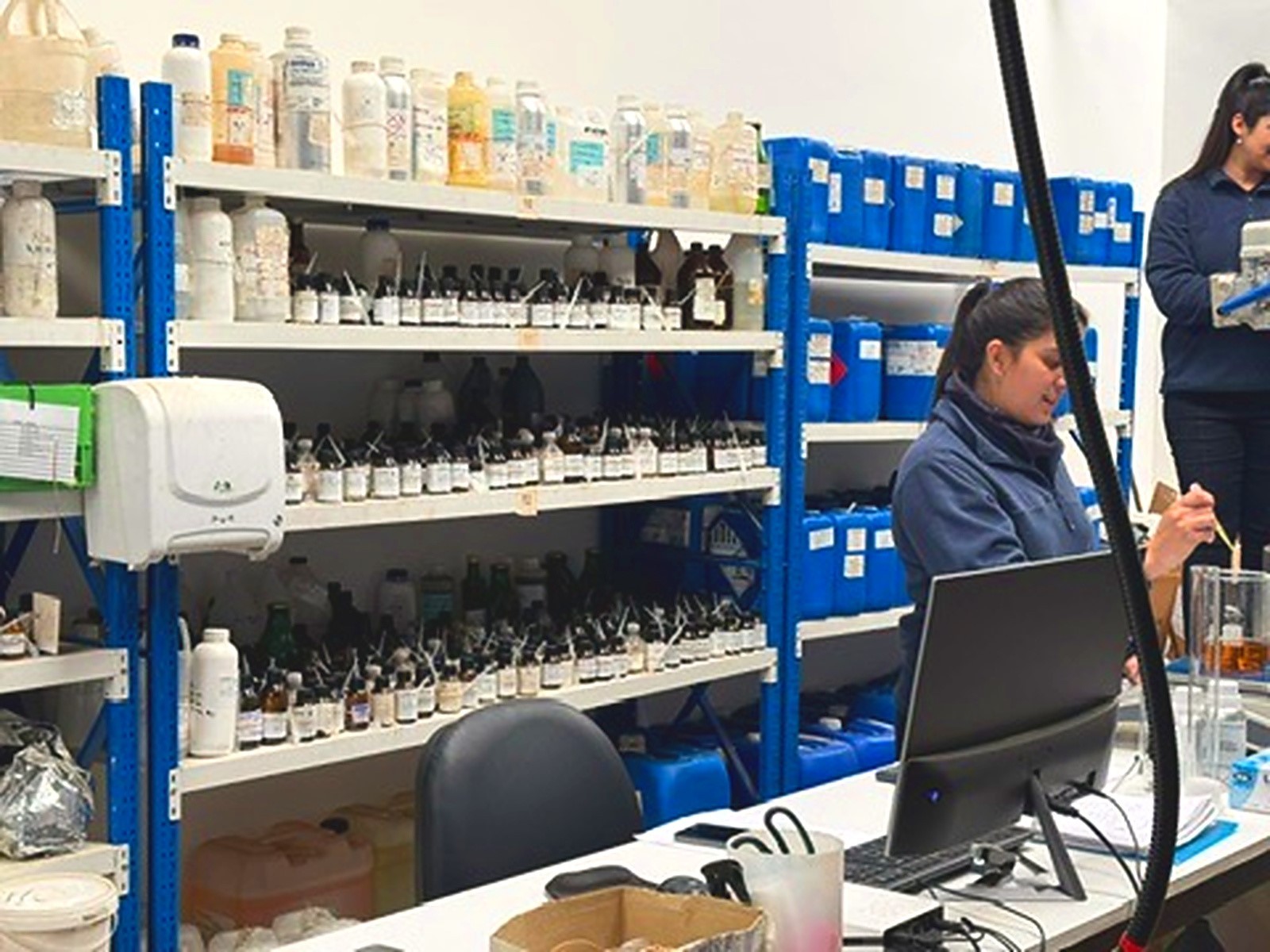 Equipo trabajando en el laboratorio de Oliê, con estantes de materias primas